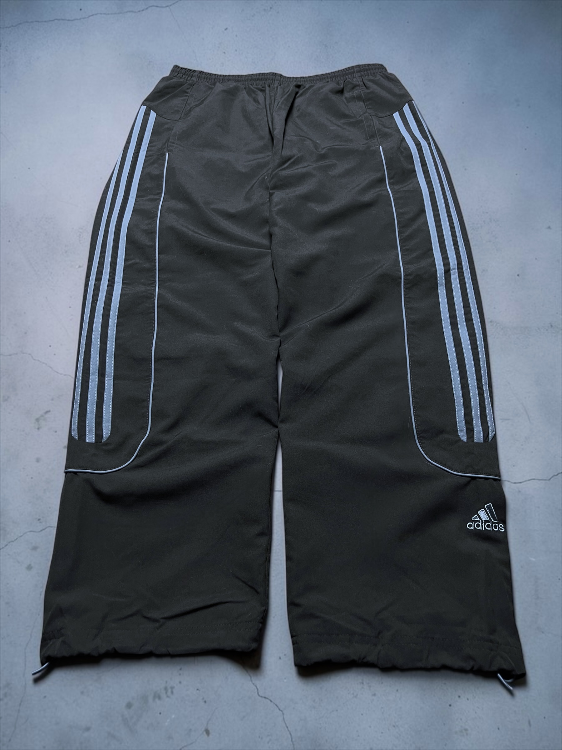 Schwarze Adidas-Trackpants mit hellblauen Streifen und Paspeln