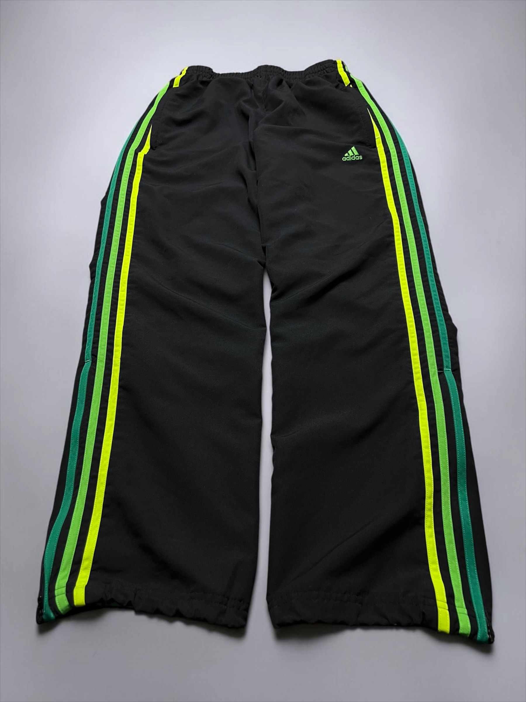 Schwarze Adidas-Trackpants mit grünen und neongelben Streifen