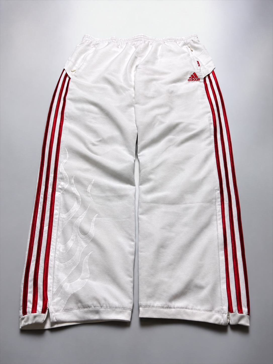 Weiße Adidas-Trackpants mit roten Streifen und dezentem Flammenmuster