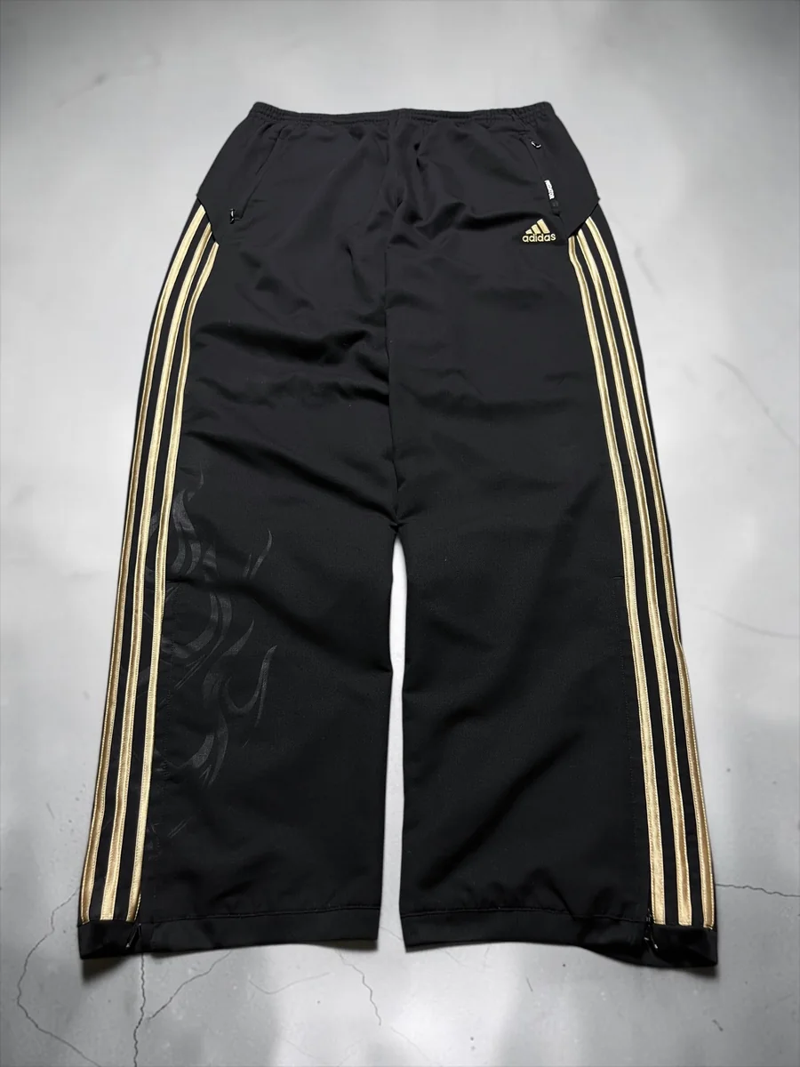 Schwarze Adidas-Trackpants mit goldfarbenen Streifen